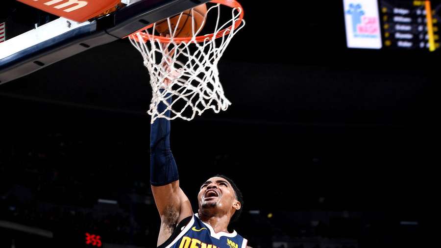 Basketballspieler dunkt den Ball in einer hell erleuchteten Arena. — Gary Bilder
