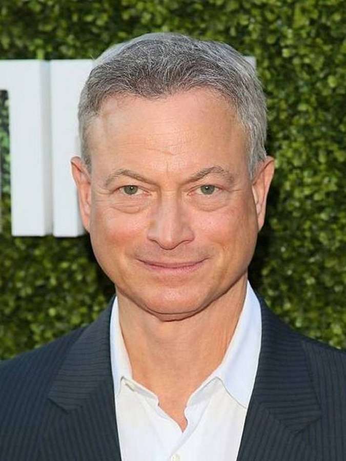 A man in a suit smiling at the camera at an event. — Gary Sinise Wallpaper