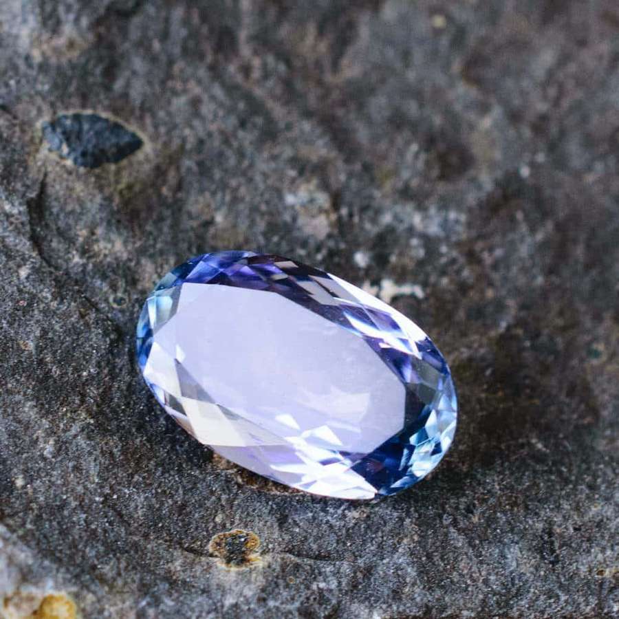 Batu permata safir biru faceted di permukaan batu abu-abu — Gemstone Wallpaper