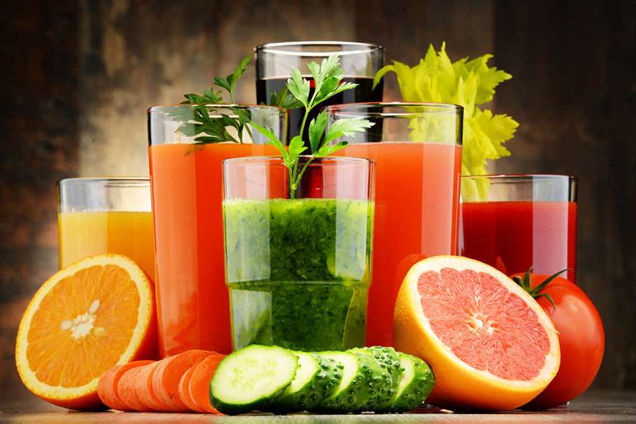 Verschiedene frische Säfte und geschnittenes Obst und Gemüse auf Holztisch. — Gemüse Wallpaper