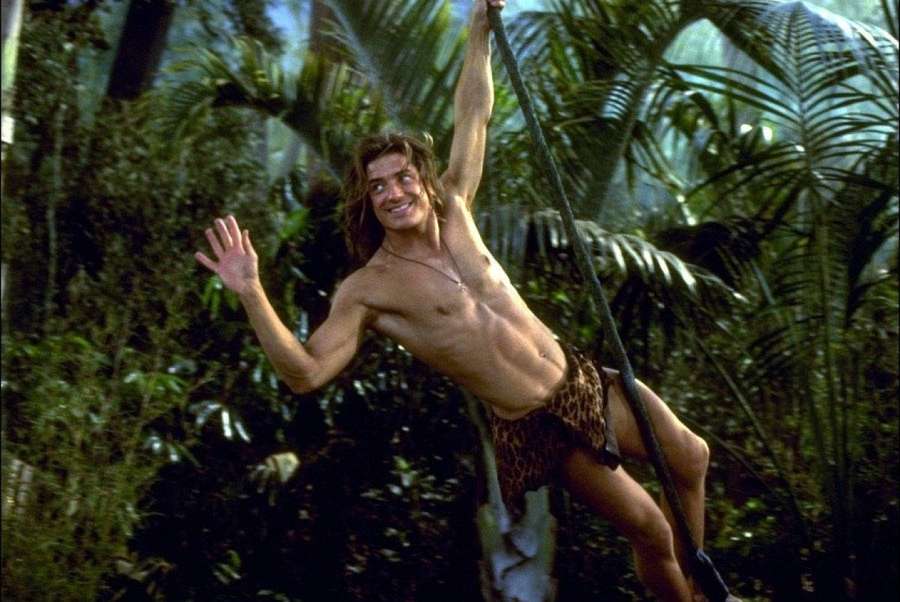 A man swinging through a dense jungle with a joyful expression. — George Background
