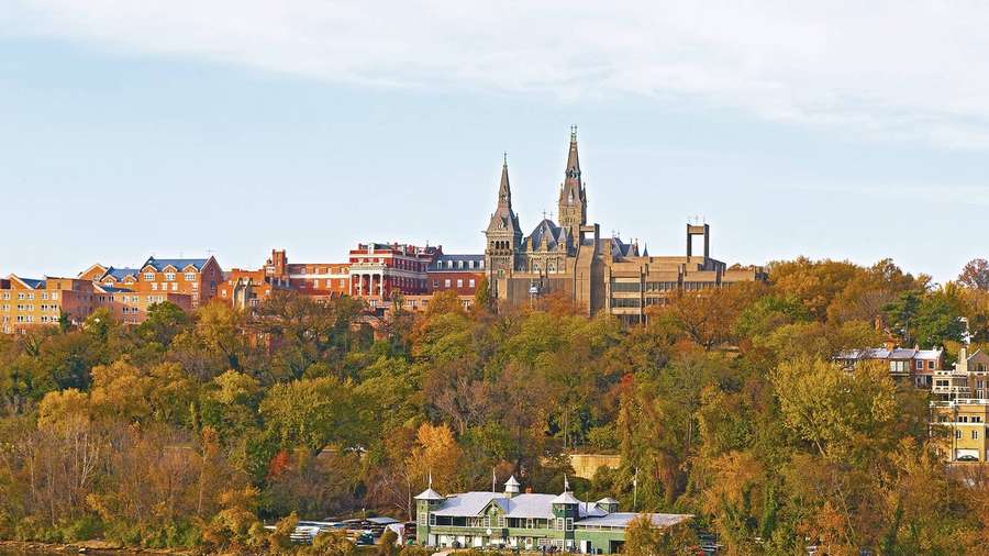 Gothic cathedral atop autumn hill with brick buildings and clear sky — Georgetown Background