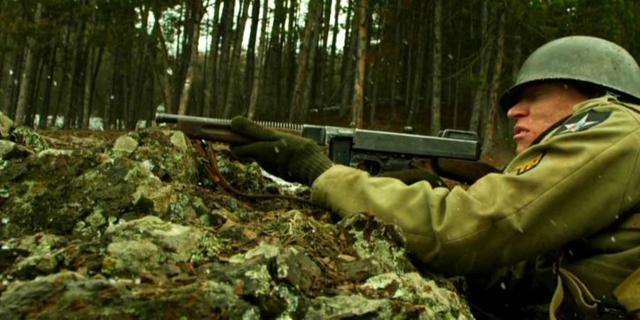 Soldat im Wald zielt mit Maschinenpistole hinter Felsen — Gesellschaft Der Helden Wallpaper