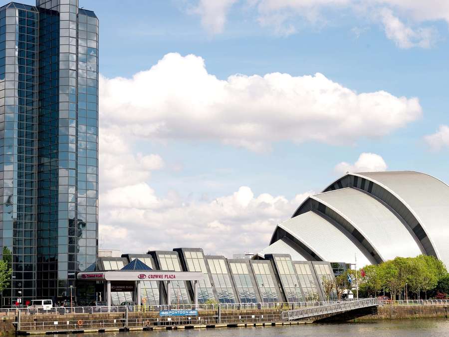 Glass tower and curved concert hall beside river under blue sky with clouds — Glasgow Wallpaper