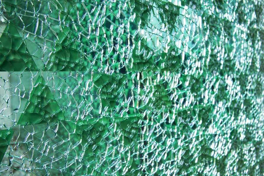 Zerbrochenes grünes Glas mit komplizierten Rissmustern und Lichtreflexionen. — Glass Texture Wallpaper