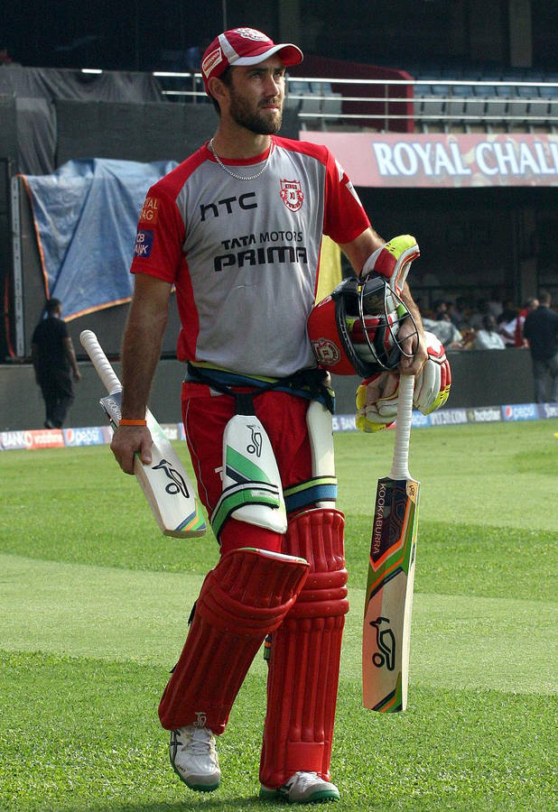 Cricket player walking off field with bat and helmet — Glenn Background