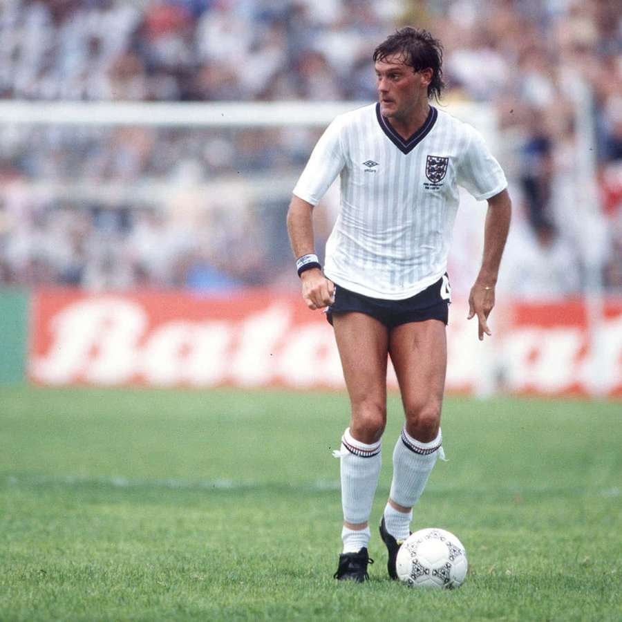 Soccer player dribbling ball on grass field during daytime match. — Glenn Hoddle Wallpaper
