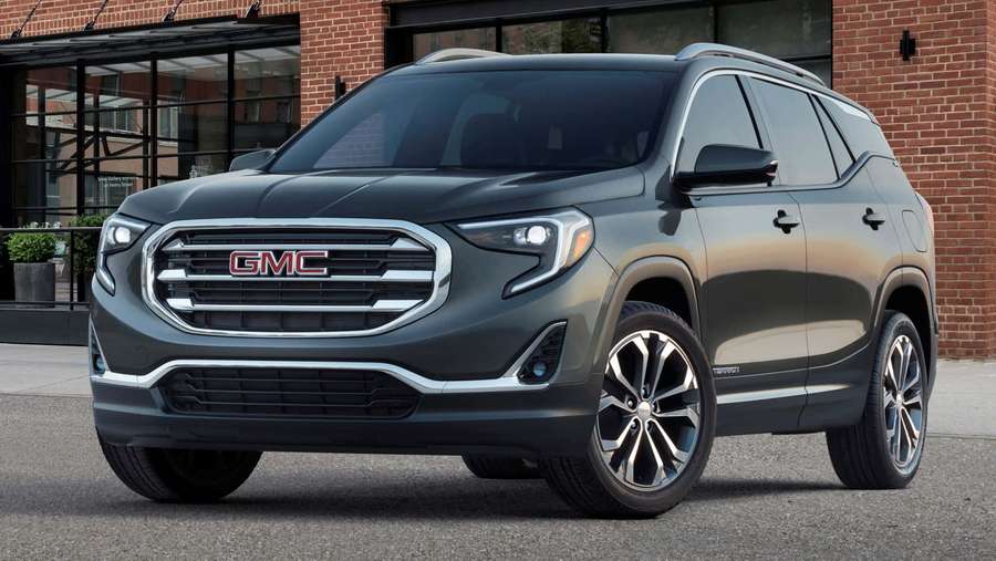 Dark gray GMC Terrain SUV parked on city street near brick building. — Gmc Terrain Wallpaper