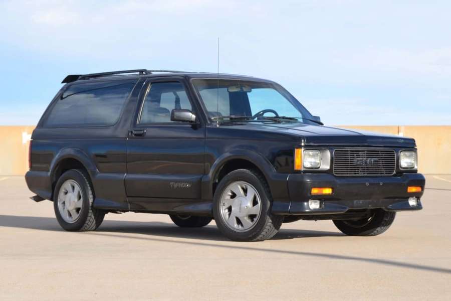 Black classic SUV parked on concrete lot under blue sky — Gmc Typhoon Wallpaper