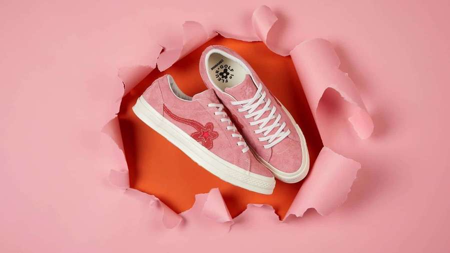 Pink suede sneakers with white laces and star logo peeking through torn pink paper. — Golf Le Fleur Wallpaper