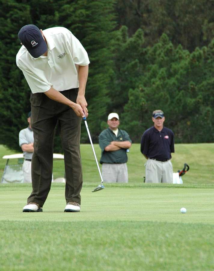 Golfspieler puttet auf Grün mit Zuschauern — Golf telefon Wallpaper
