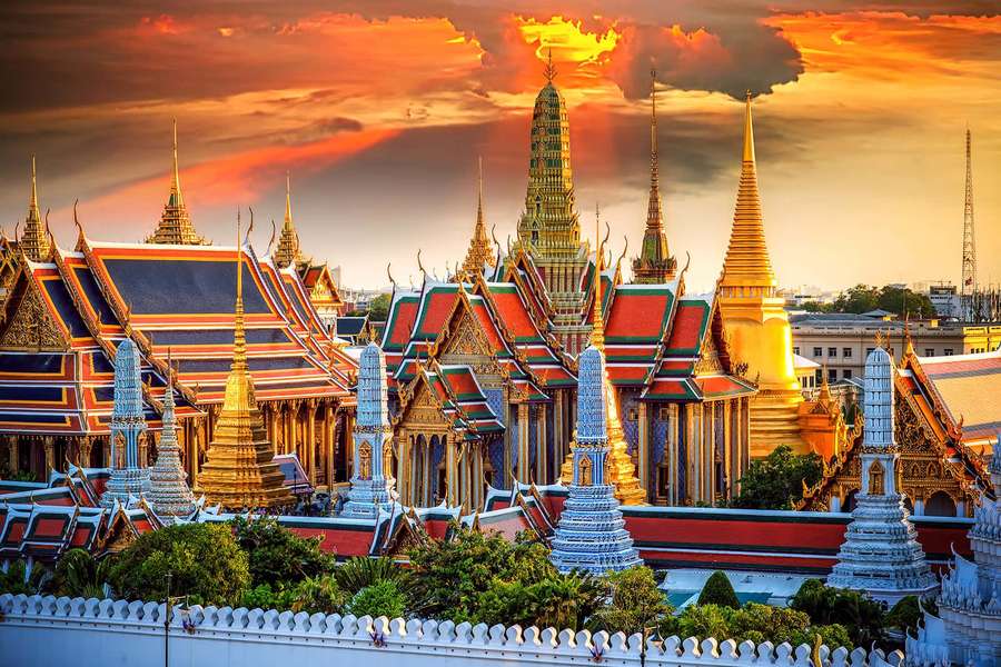 Grand Palace in Bangkok at sunset with golden spires and red roofs. — Grand Palace Wallpaper