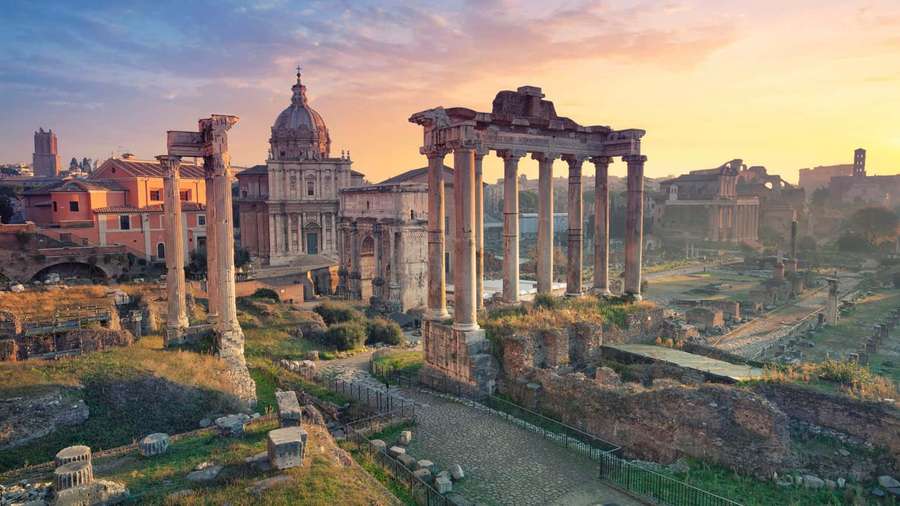 Sunset over ancient Roman ruins with standing columns and domed church. — Greece Aesthetic Wallpaper