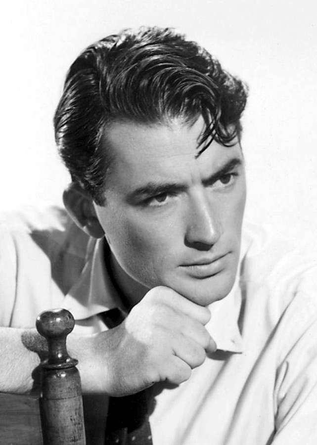 Handsome man in classic 1950s portrait with styled hair resting chin on fist. — Gregory peck Wallpaper