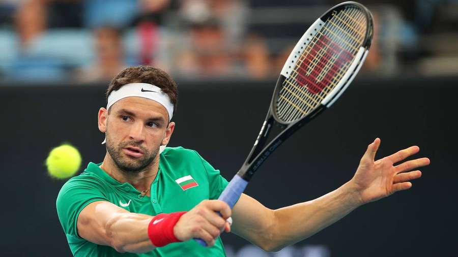 Tennis player in green shirt hitting a yellow ball with racket during match. — Grigor Dimitrov Background