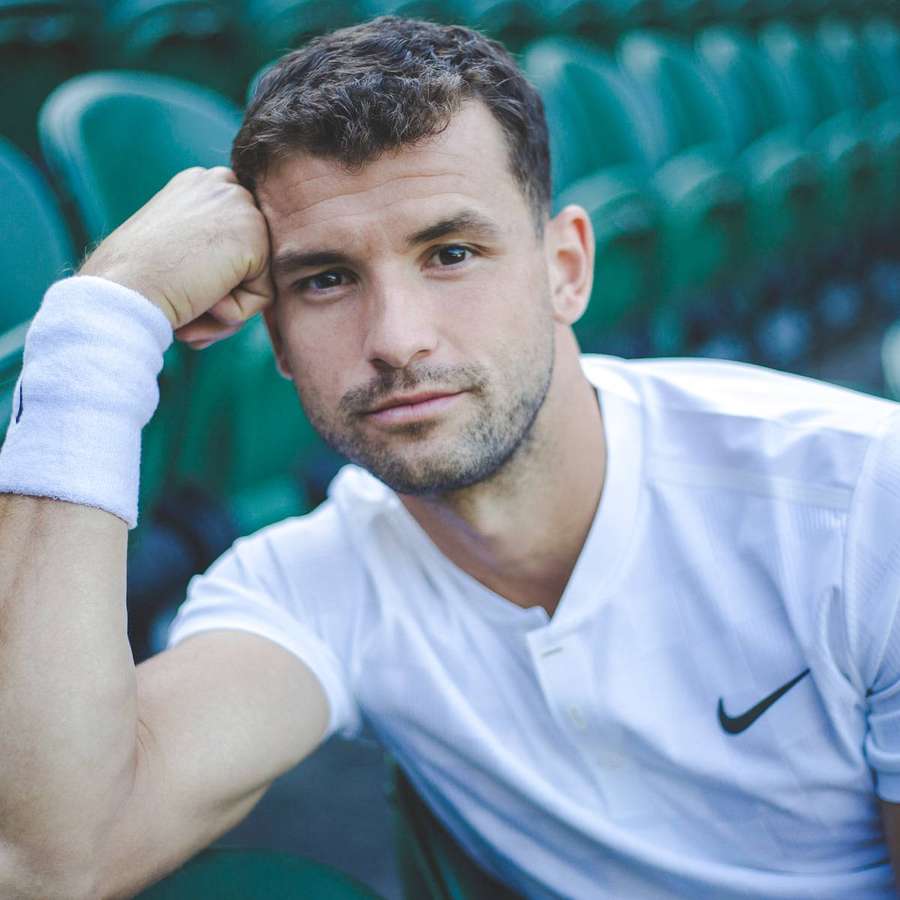 Tennis player in white shirt resting hand on head at stadium — Grigor Dimitrov Wallpaper