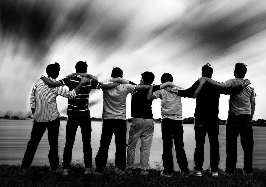Seven friends linked arms standing by a lake under a dramatic sky. — Group Background