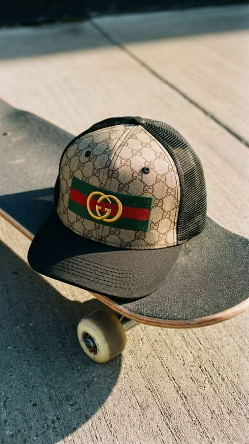 Gucci trucker hat on skateboard, urban streetwear, high-angle, concrete. — Gucci Hat Picture
