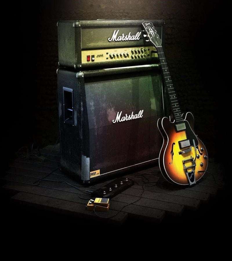 Sunburst elektrisk guitar lænet op ad Marshall forstærker i mørkt studie — Guitar Amp Wallpapers