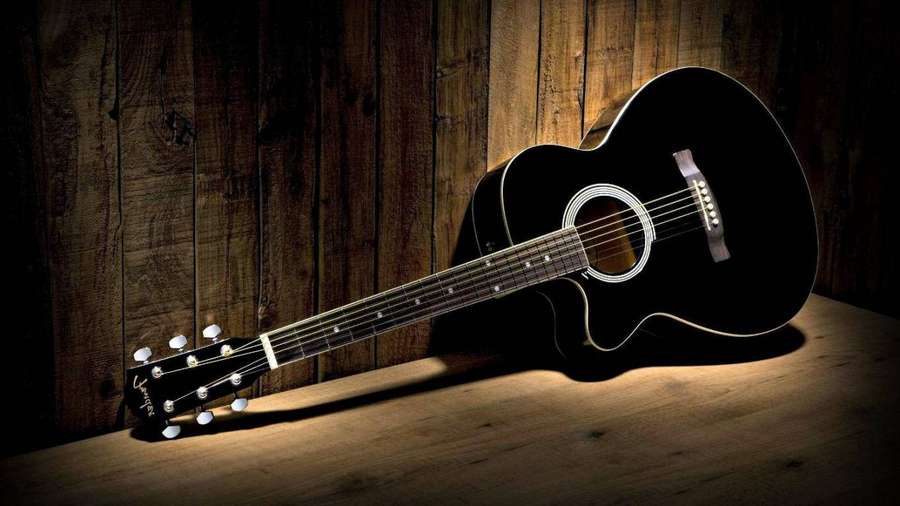 Guitarra acústica negra sobre mesa de madera contra pared de madera con foco. — Guitar Fondos de pantalla