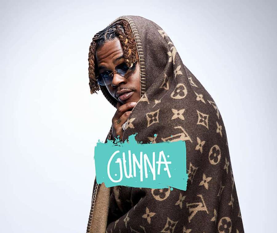 Man with braids and sunglasses draped in a Louis Vuitton blanket with 'GUNNA' text overlay. — Gunna Wallpaper