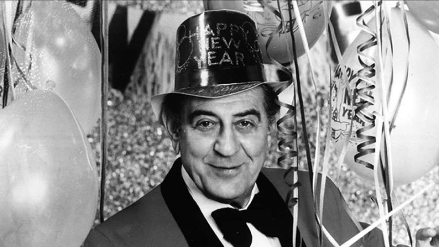 Man in tuxedo and New Year hat surrounded by balloons at celebration. — Guy Lombardo Wallpaper