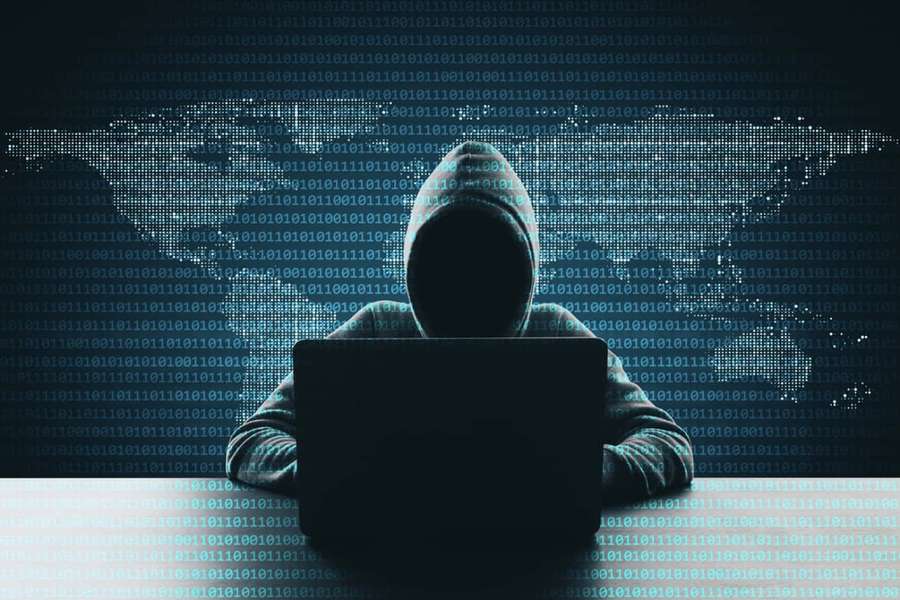 Anonymous hacker working on laptop with digital world map and binary code background. — Hacker Picture