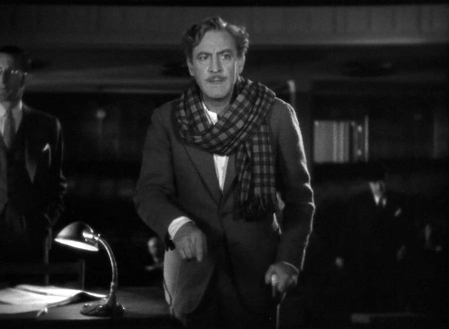Man in suit and plaid scarf standing in dim office with desk lamp. — Hamlet Background
