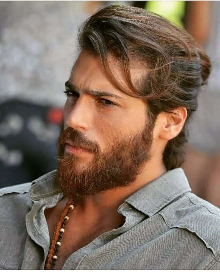 A man with a beard and styled hair wearing a gray shirt and necklace. — Handsome Man Background