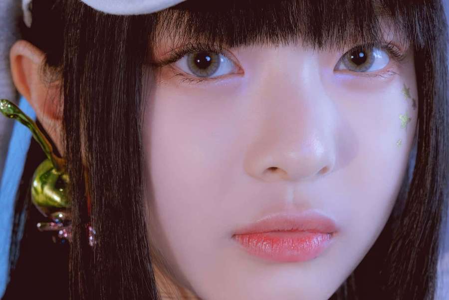 Young woman with dark hair and star glitter on cheek wearing large earring. — Hanni Wallpaper