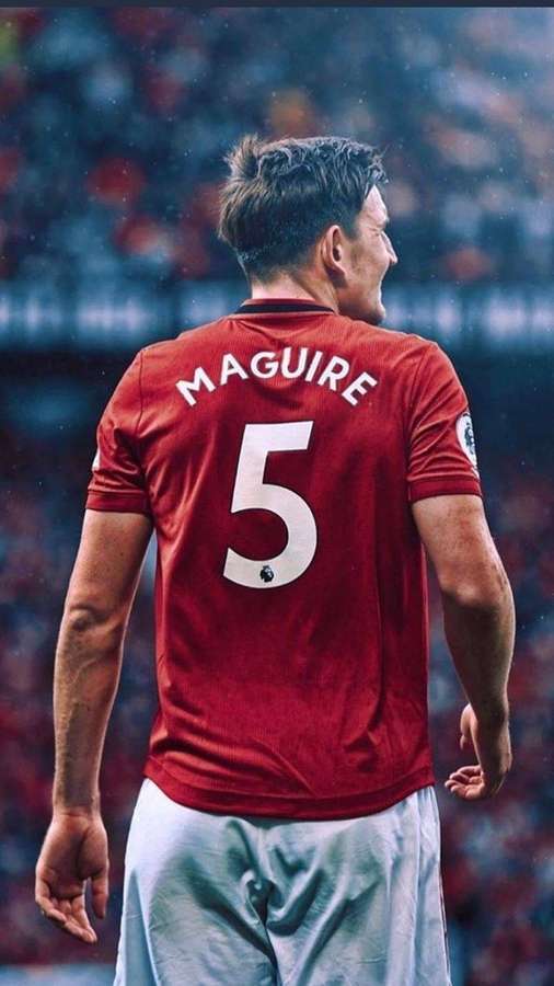 Fußballspieler Harry Maguire im roten Manchester United-Trikot Nummer 5 steht im Regen im Stadion. — Harry Maguire Bilder