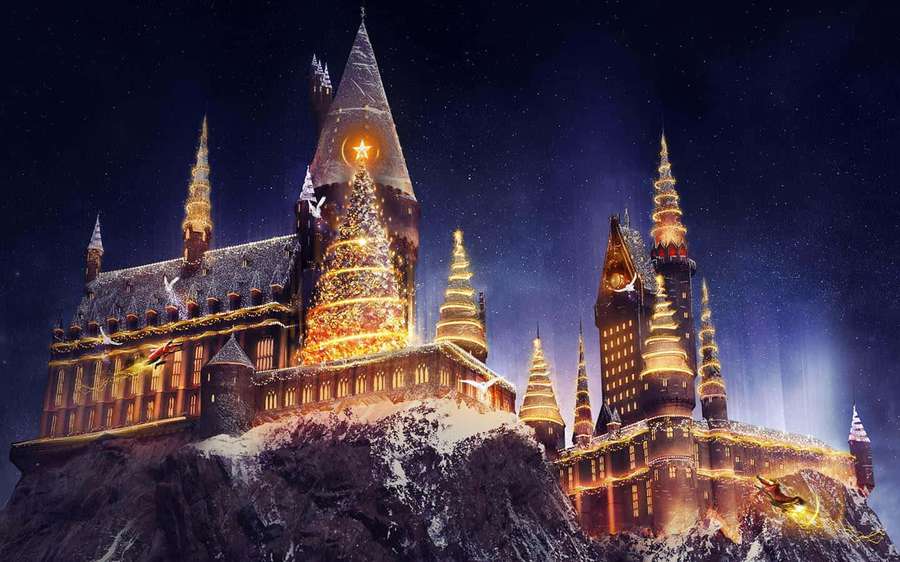 A magical castle covered in snow with glowing lights under a starry night sky. — Harry Potter Christmas Wallpaper