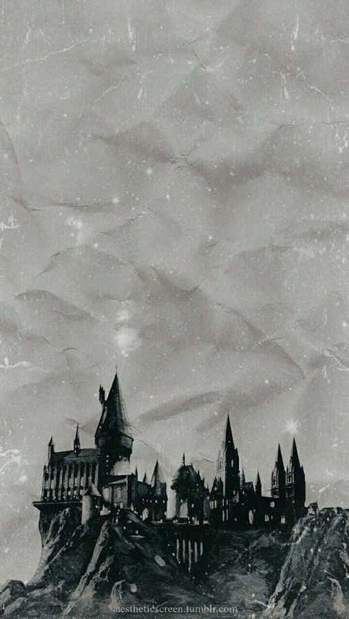 Silhueta do Castelo de Hogwarts em um penhasco sob um céu noturno nublado com estrelas. — Harry Potter preto e branco Papéis de Parede