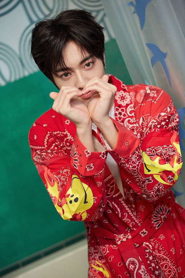 Young man making heart shape with hands wearing red patterned shirt — Haruto Wallpaper