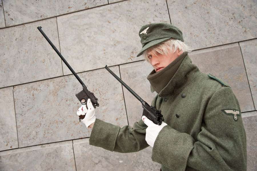 Persona con uniforme militar sosteniendo dos pistolas contra una pared de piedra. — Hellsing El Capitán Fondos de pantalla