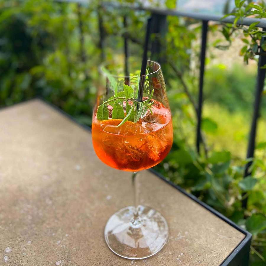 Un refrescante cóctel naranja con hielo y hierbas sobre una mesa de piedra. — Hermosa bebida Fondos de pantalla