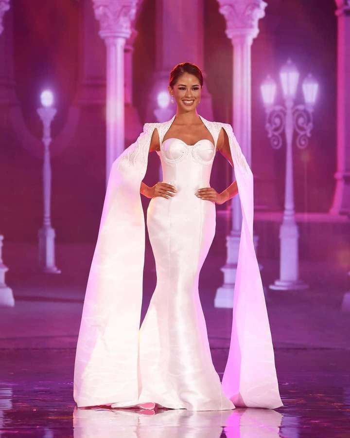 Mujer con vestido blanco posando en escenario iluminado con iluminación púrpura. — Hermosa moda Fondos de pantalla