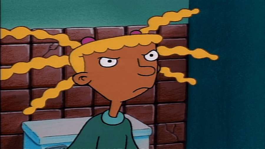 Cartoon-Mädchen mit lockigen gelben Haaren, das vor einer Backsteinmauer die Stirn runzelt. — Hey Arnold Bilder