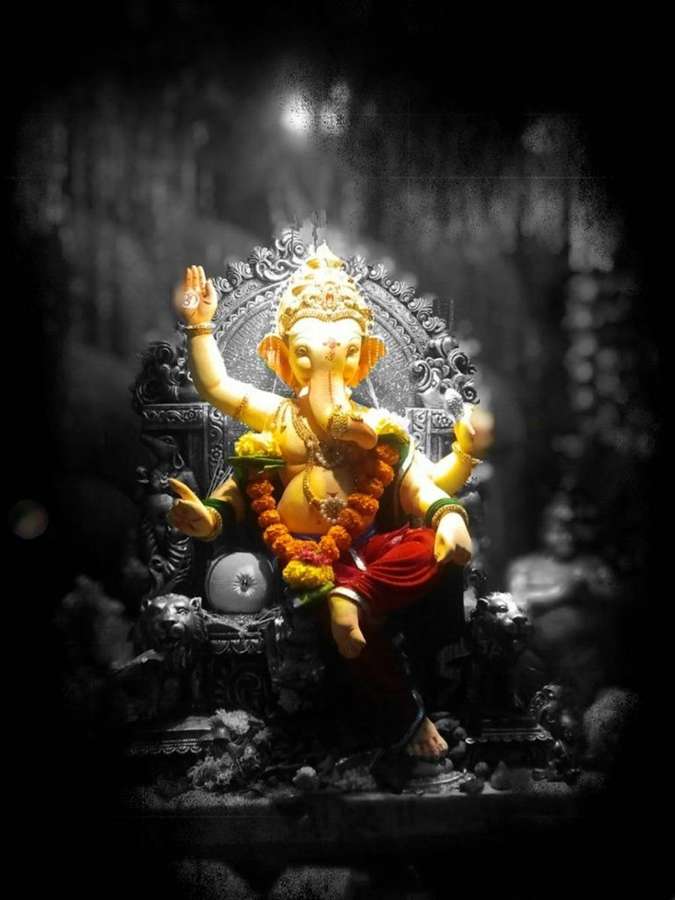 Gylden Ganesha-statue siddende på en udsmykket trone i mørke omgivelser. — Hindu iPhone Wallpapers