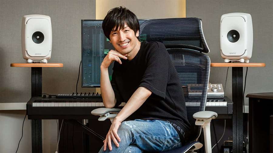 Man smiling in music studio with keyboard and speakers — Hiroyuki Sawano Wallpaper