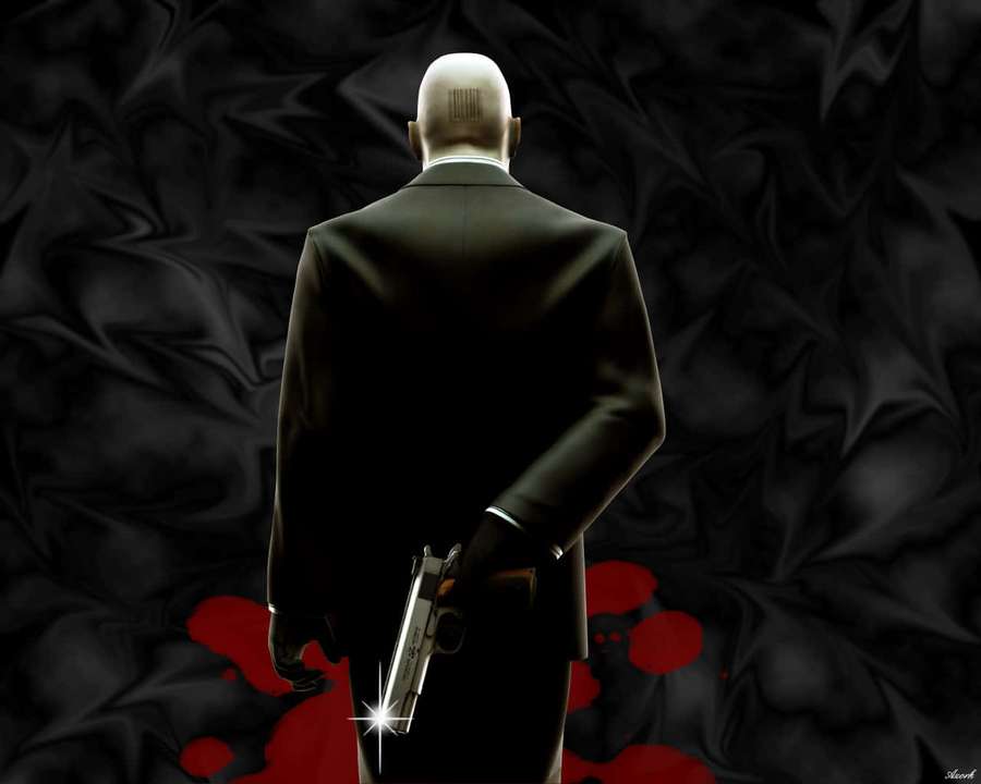 Back view of a bald assassin in a black suit holding a gun with red blood splatters on black fabric. — Hitman 2 Background