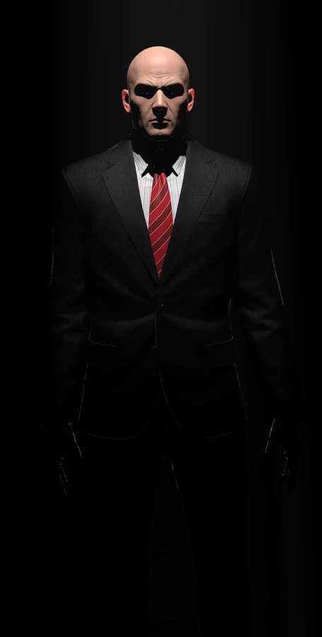 Ein kahlköpfiger Mann in einem schwarzen Anzug und einer roten Krawatte steht in dunklem Licht. — Hitman Bilder