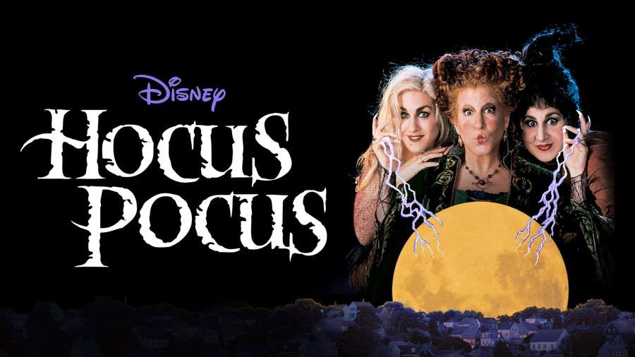 Three witches with lightning bolts pose before a full moon over a suburban town. — Hocus Pocus Background