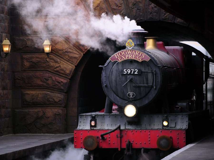 Hogwarts Express steam train emerging from stone archway at platform — Hogwarts Express Wallpaper