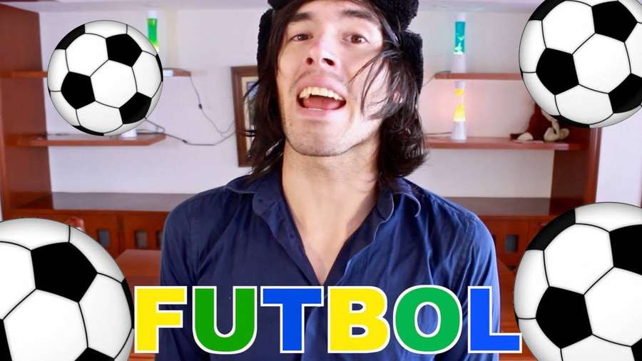 Man laughing with floating soccer balls and colorful futbol text. — Holasoygerman Wallpaper