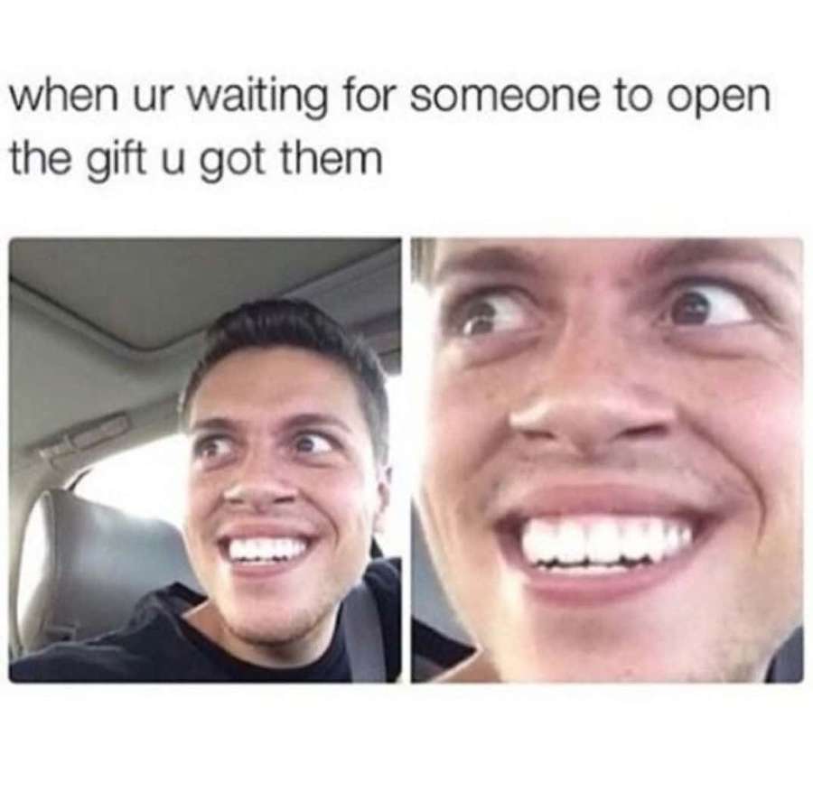 Man in car smiling nervously while waiting for someone to open a gift. — Holiday Memes Wallpaper