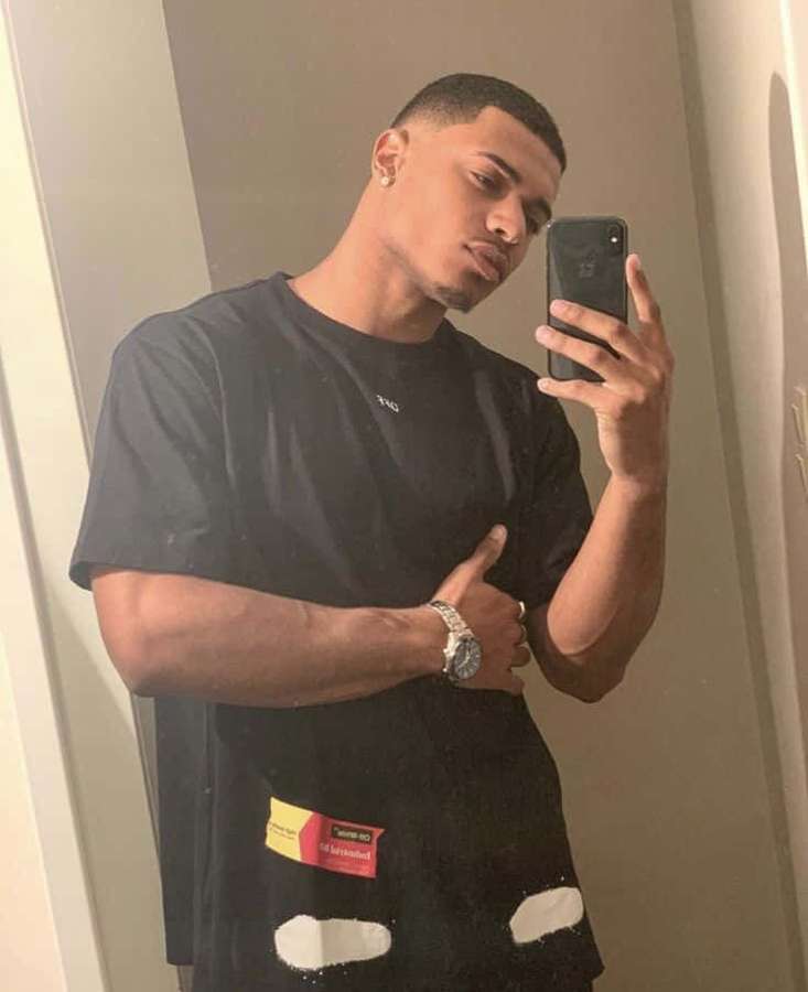 Joven tomándose una selfie en el espejo con camiseta negra rota y reloj plateado — Hombre Fondos de pantalla