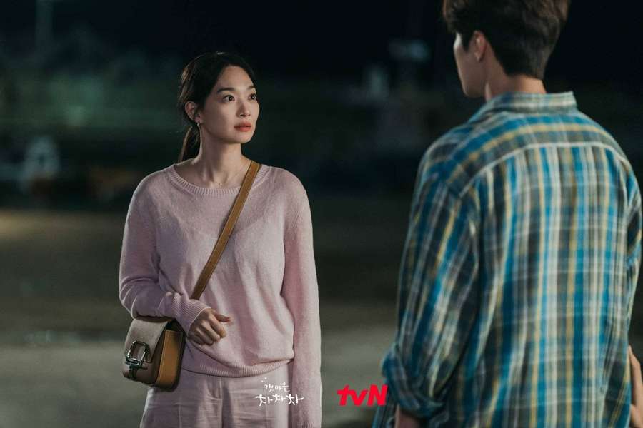 Woman in pink sweater facing man in plaid shirt at night under streetlights. — Hometown Background