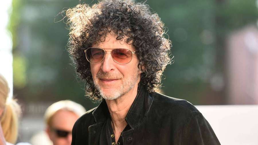 Mann mit lockigem Haar und Sonnenbrille lächelt im Freien — Howard Wallpaper