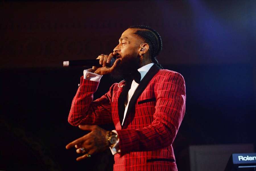 Rapper in red suit singing into microphone on stage — Hussle Wallpaper